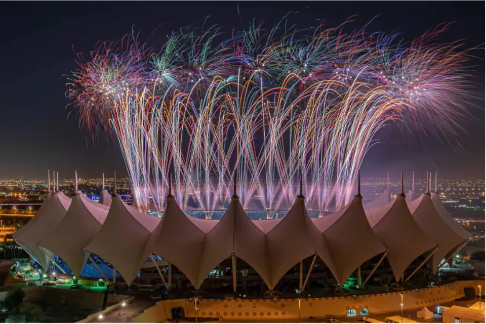 Fireworks above a large stadium at night